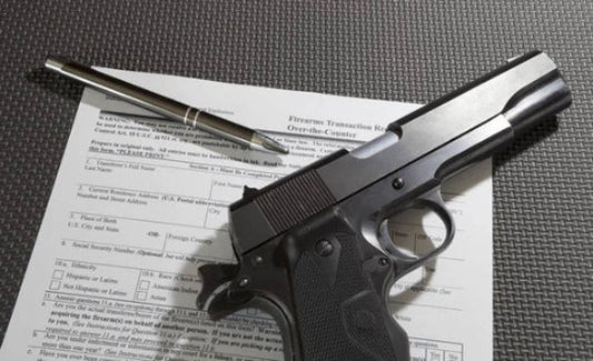 Handgun and firearm transaction form on a gray surface